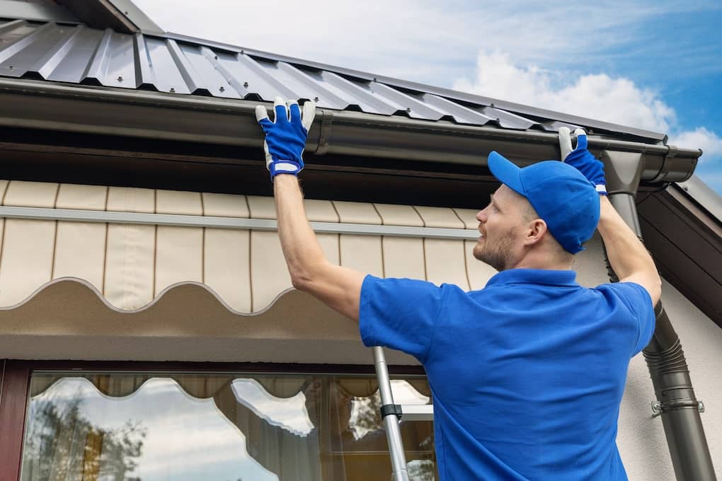 local roofer installing house roof rain gutter system