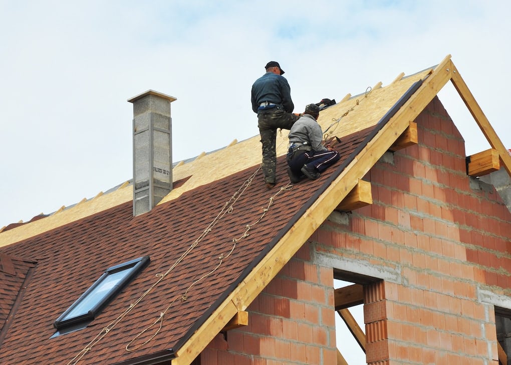 Roofers laying tiles on the roof for roof repair