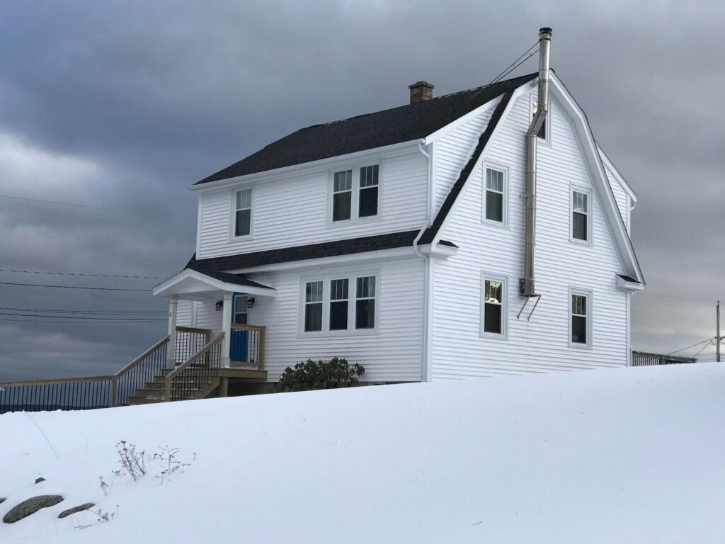 home with black roofing and siding that is white