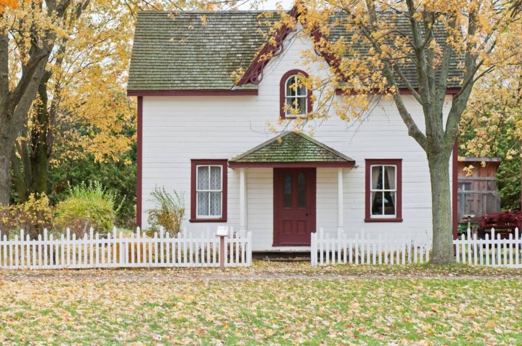 white home with maroon trim and gray roofing