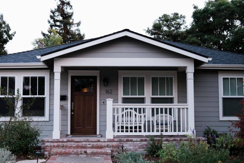 gray siding with a contrasting roof and wooden door 