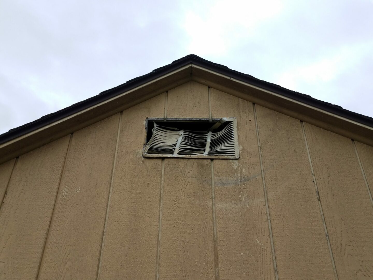 damaged metal vent on brown home