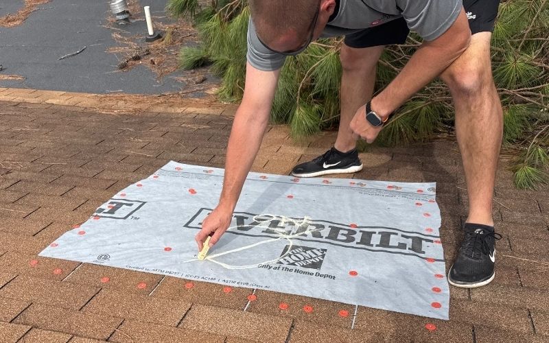 Roofing consultant marking roof damage during inspection